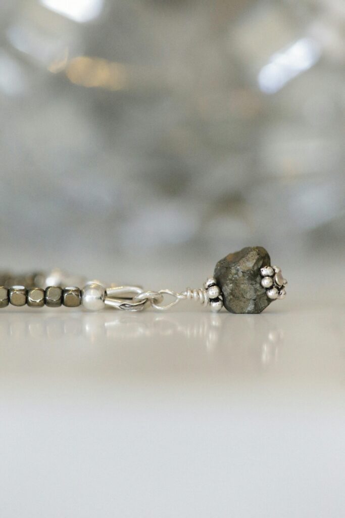 Detailed close-up of a silver and stone bracelet with blurred background.