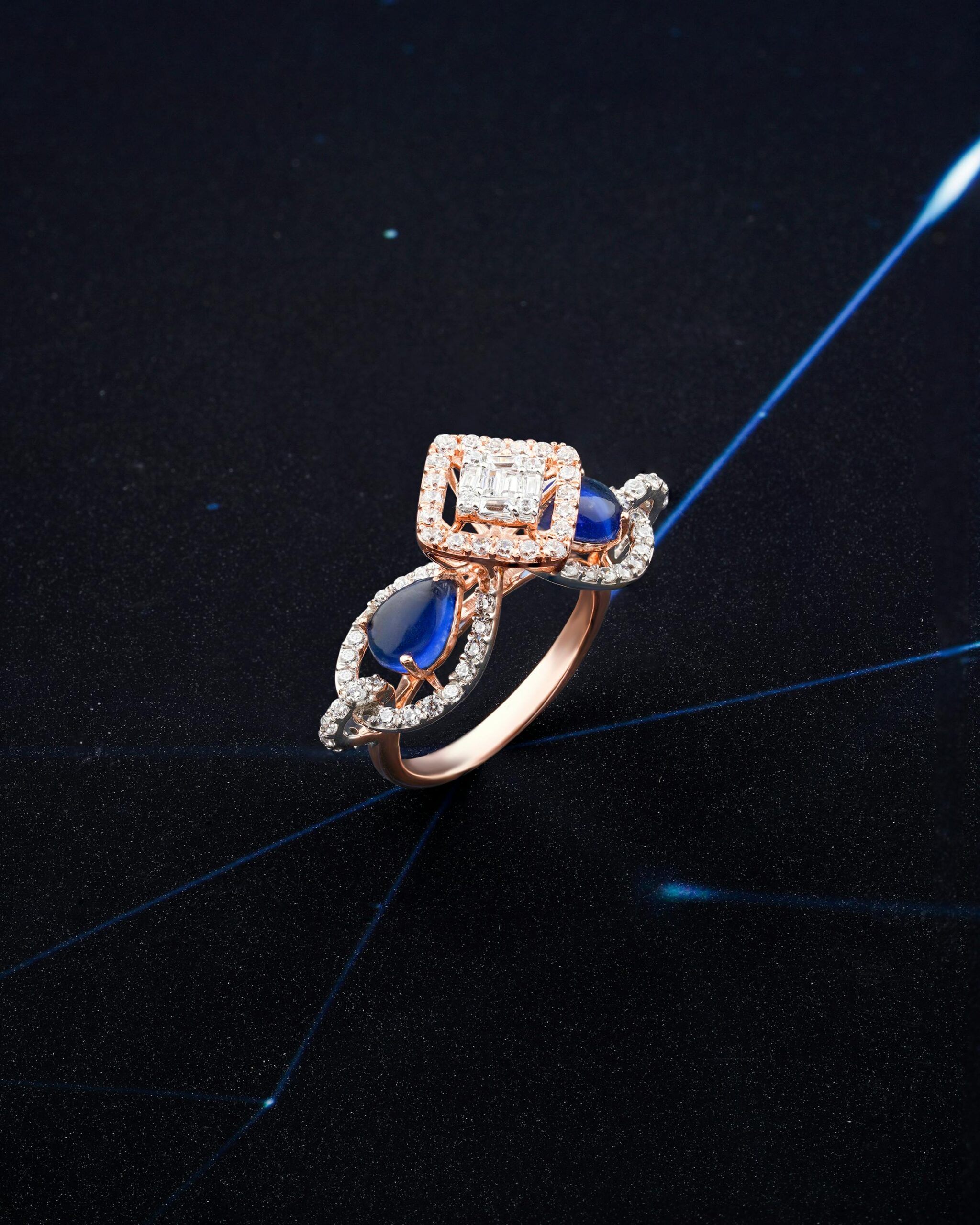 Luxurious sapphire and diamond ring set in gold, captured on a sleek black background with sparkling highlights.