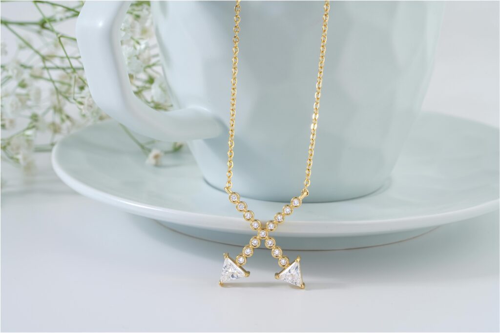 A luxurious gold necklace adorned with diamonds elegantly draped over a ceramic cup. Perfect for jewelry enthusiasts.