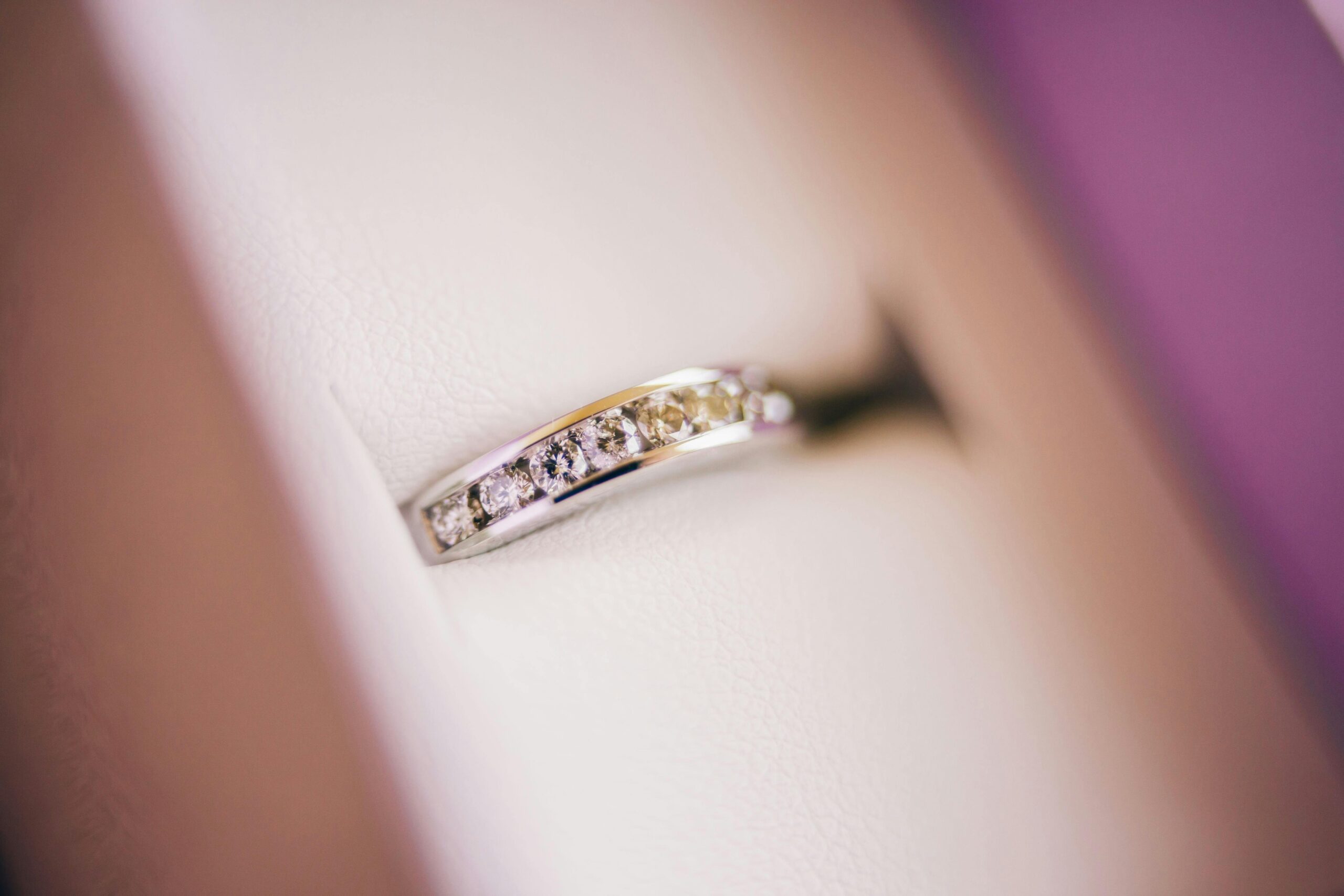 Close-up of a diamond wedding ring in soft lighting, showcasing luxury and elegance.